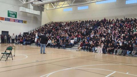 Brian Yazzie performing for a packed gymnasium