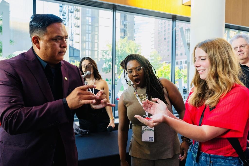 Brian Yazzie performing walk-around magic at a conference — crowd amazed