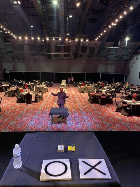 Brian Yazzie on stage in a large ballroom event venue