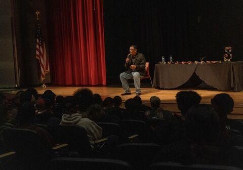 Brian Yazzie speaking to a packed school auditorium