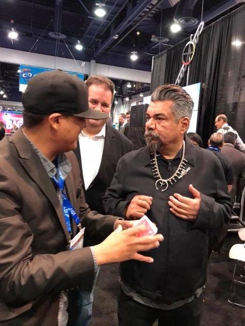 Brian Yazzie performing magic for George Lopez at a trade show